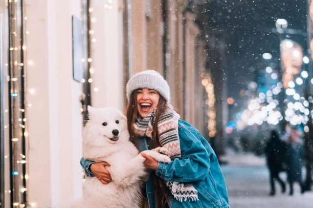 Woman hugging dog snowy night