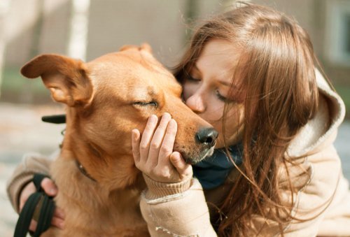 Woman kisses dog